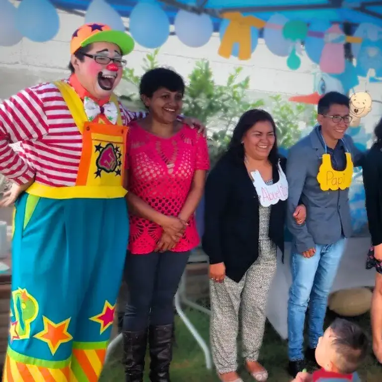 El Payaso Payín posa con las invitadas de un baby shower en un jardín decorado