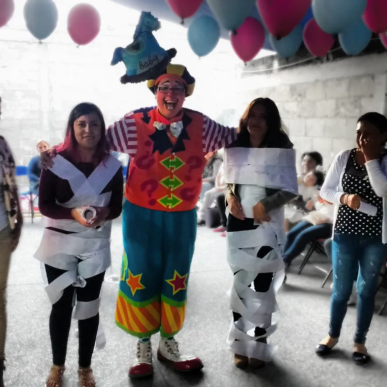 Invitadas adultas participan en un juego con el Payaso Payín durante una fiesta