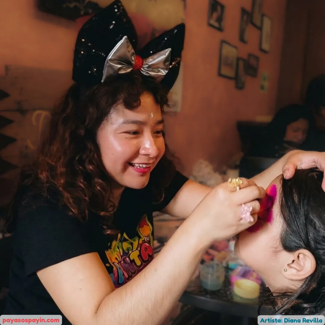 Maquillista profesional de Payín pintando con paciencia y cariño la carita de una niña en fiesta infantil