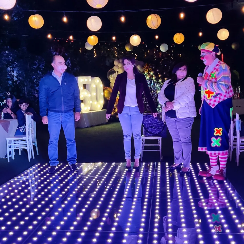 Payasos Payín anima la cena de fin de año de una empresa con invitados adultos en una pista iluminada