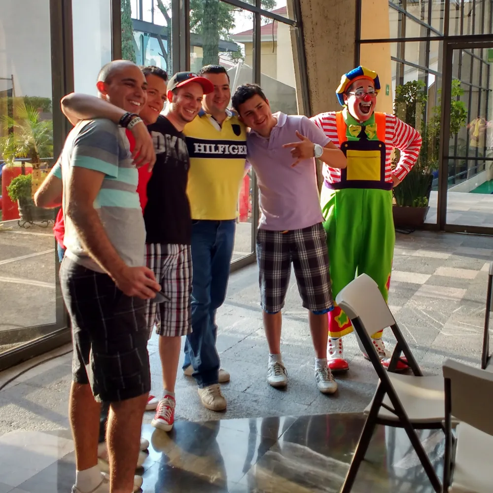Colaboradores de una empresa posan con el Payaso Payín después de un show de comedia con humor blanco