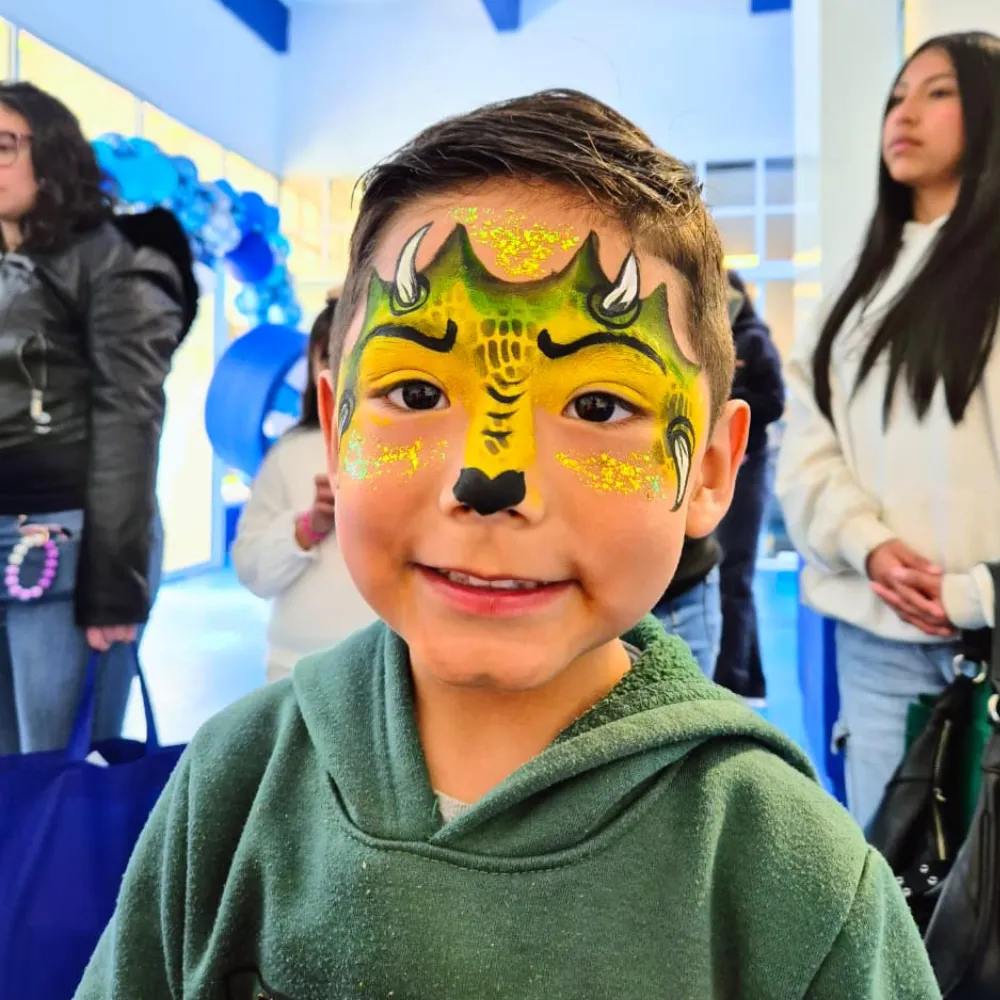 Un niño luce un pintacaritas de fantasía hecho por una maquillista de Payasos Payín en un evento de empresa