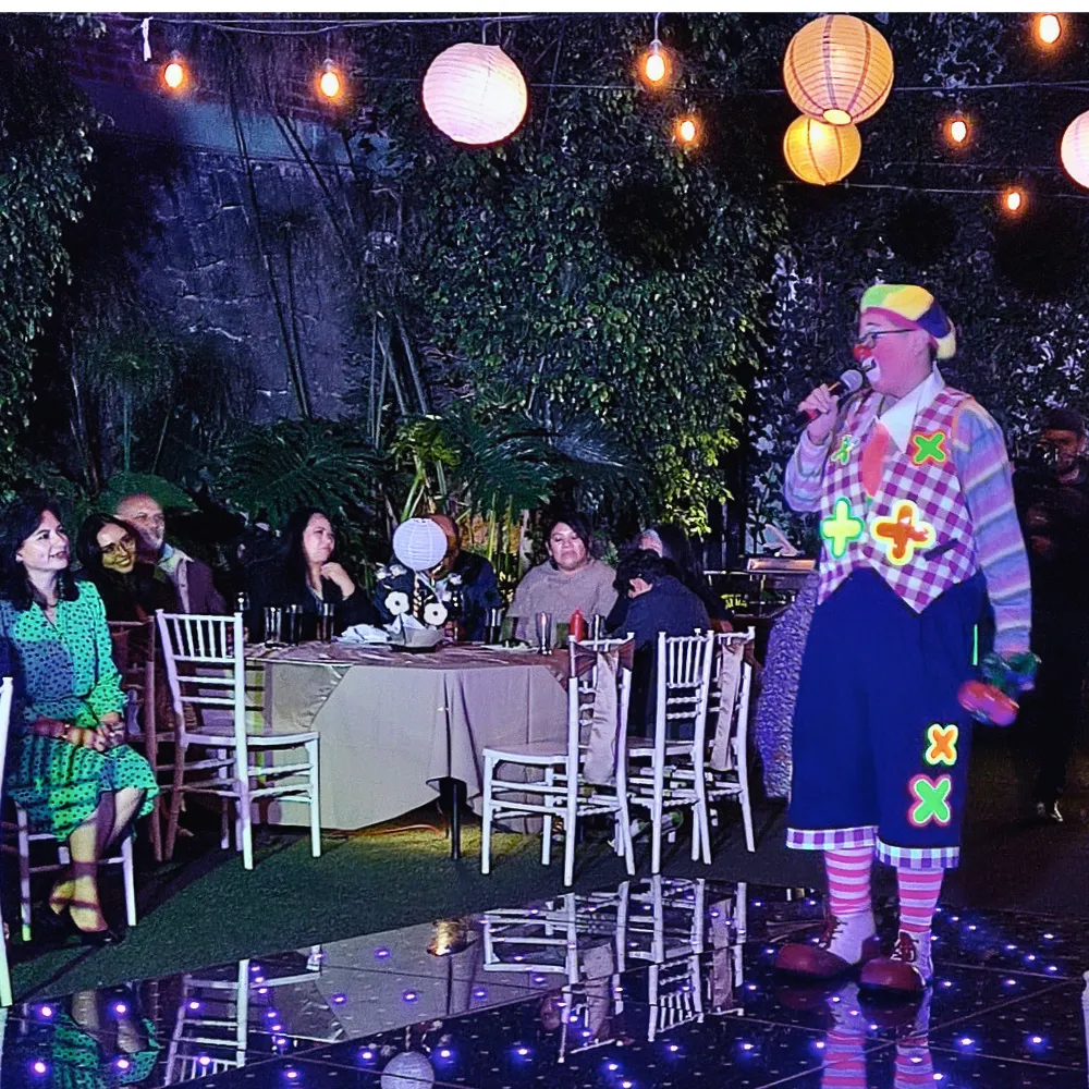 El Payaso Payín anima a los colaboradores en la fiesta de fin de año de una empresa, entre mesas decoradas y luces