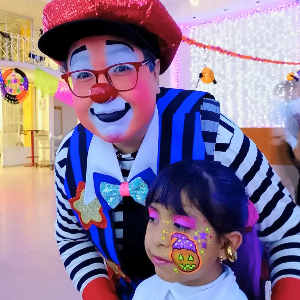 Niña con pintacaritas de calabaza de Halloween con sombrero de brujita junto al Payaso Payín en CDMX y EDOMEX