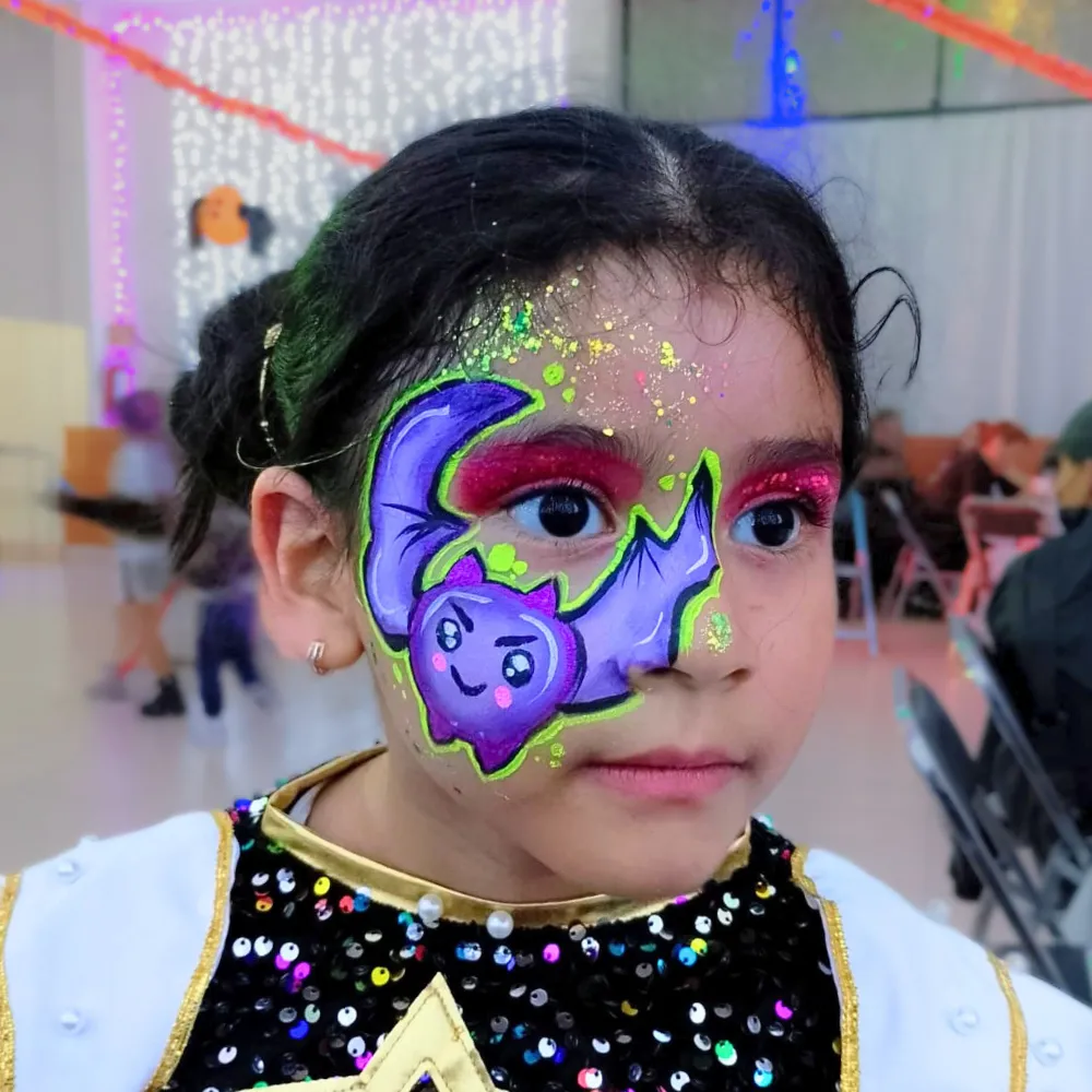 Pintacaritas de murciélago morado kawaii con luna y contorno verde neón con glitter para niñas en CDMX y EDOMEX