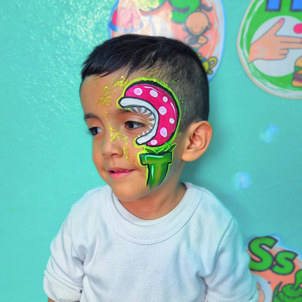 Pintacaritas de Planta Piraña de Mario Bros con tubería verde y glitter dorado para niños