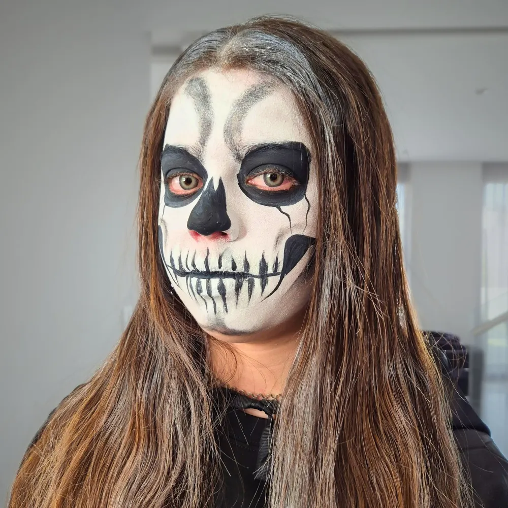 Maquillista de Payasos Payín pinta una calavera realista en rostro completo a una mujer adulta para Halloween en CDMX y EDOMEX
